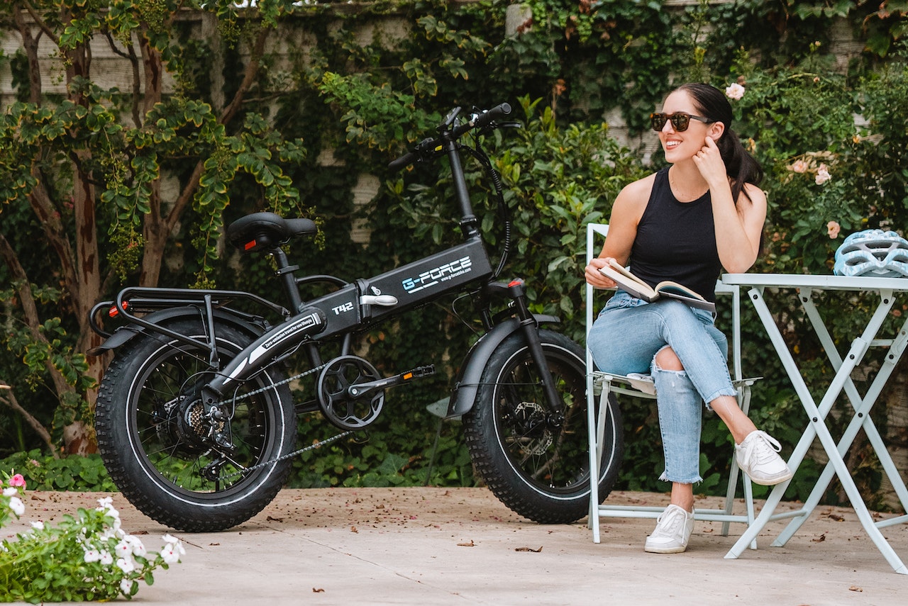 une femme à côté d'un vélo électrique