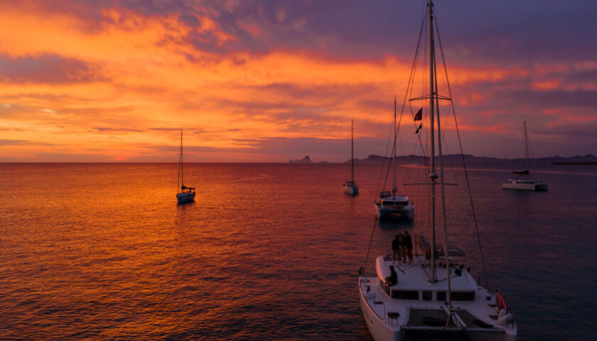 Plusieurs bateaux face à un coucher de soleil
