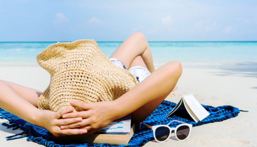 une femme bronzant sur la plage au soleil